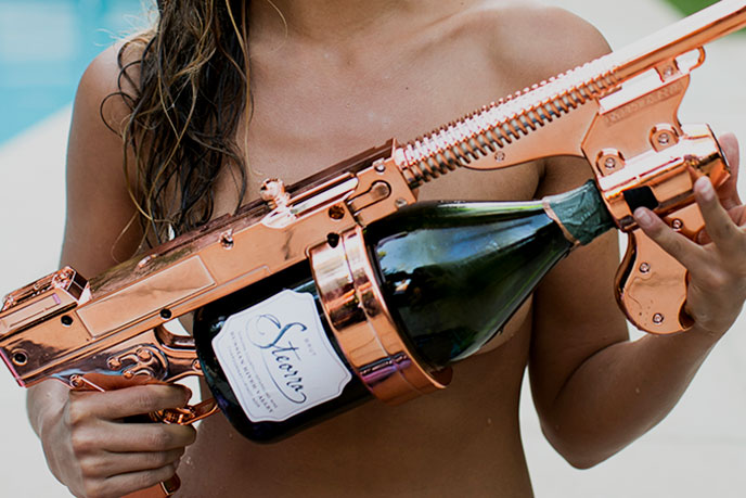 Steorra lifestyle image, lady holding rosé colored champagne gun with bottle of Steorra champagne